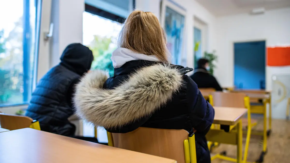 26.10.2020, Nordrhein-Westfalen, Gütersloh: Eine Schülerinn sitzt zum Schulbeginn in Nordrhein-Westfalen nach den Herbstferien mit ihrer Winterjacke bei geöffneten Fenstern in einer Klasse der Freiherr-vom-Stein-Realschule in Gütersloh. Ein wichtiges Element in den Hygienekonzepten der Schulen zum Schutz vor Corona ist das intensive Lüften der Klassenräume. Viele Schüler und Eltern fürchten, dass es in den kommenden Wochen und Monaten in den Klassenräumen kalt werden könnte. Alle 20 Minuten Stoßlüften lautet die Vorgabe vom Schulministerium. Eine Maßnahme, die dafür sorgen soll, dass die Aerosol-Konzentration und damit das Corona-Risiko nicht zu stark ansteigen. Foto: Guido Kirchner/dpa +++ dpa-Bildfunk +++