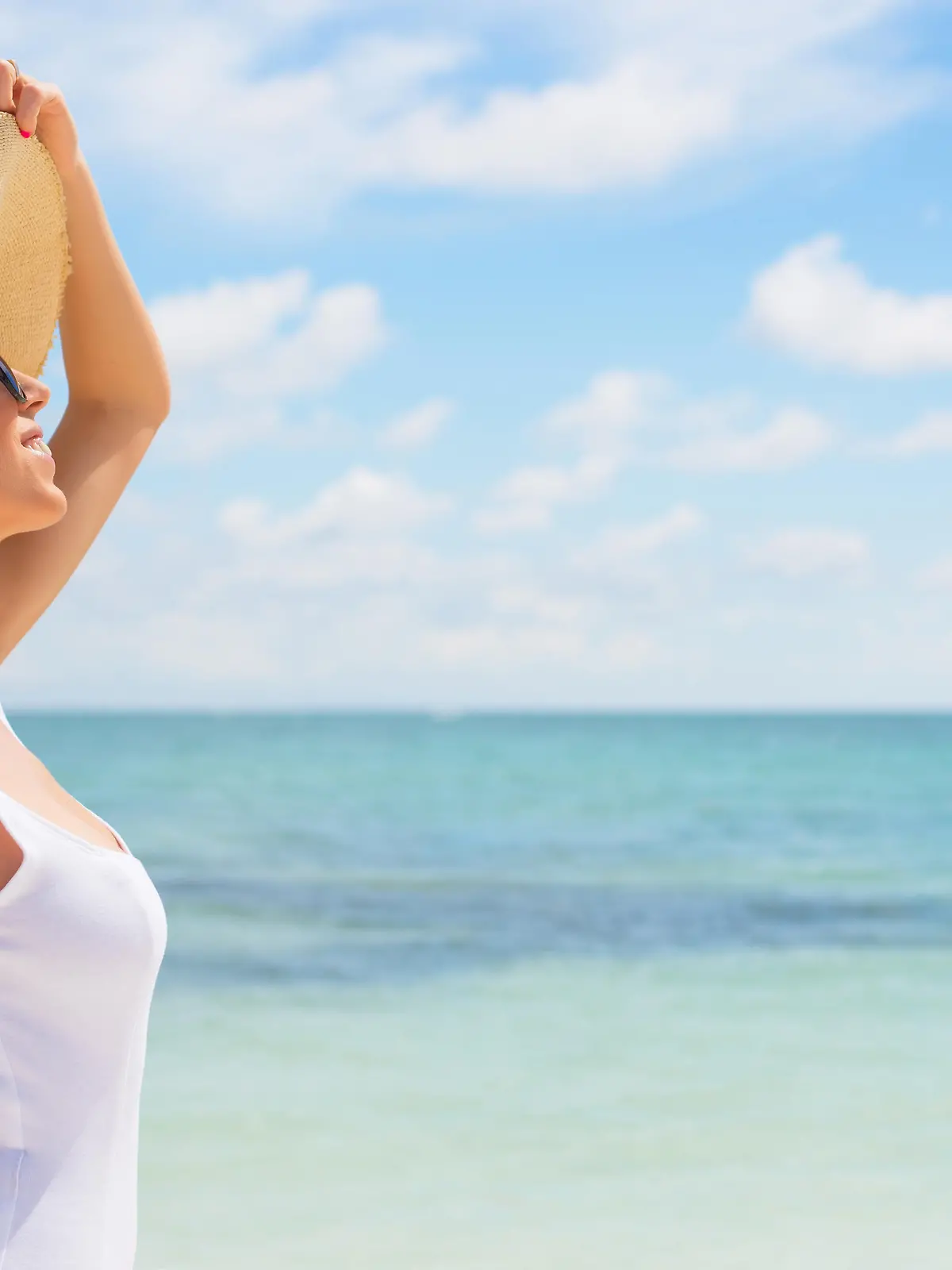 Portrait of young woman with sun hat on the beach