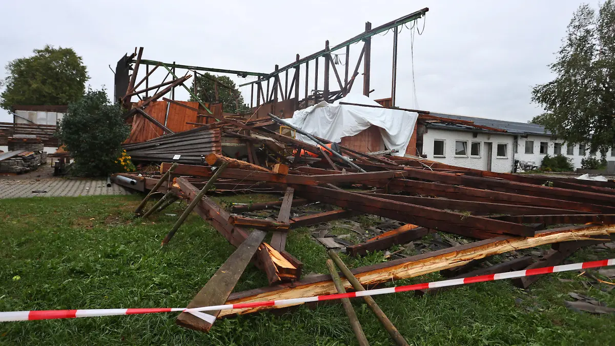 06.08.2022, Baden-Württemberg, Bad Wurzach: Die Überreste einer Lagerhalle stehen im Ortsteil Rohr. Bei einem Sturm wurde das Dach von der Materialhalle weggefegt. Es befindet sich nun 300 Meter von dem Gebäude entfernt, Foto: Karl-Josef Hildenbrand/dpa +++ dpa-Bildfunk +++