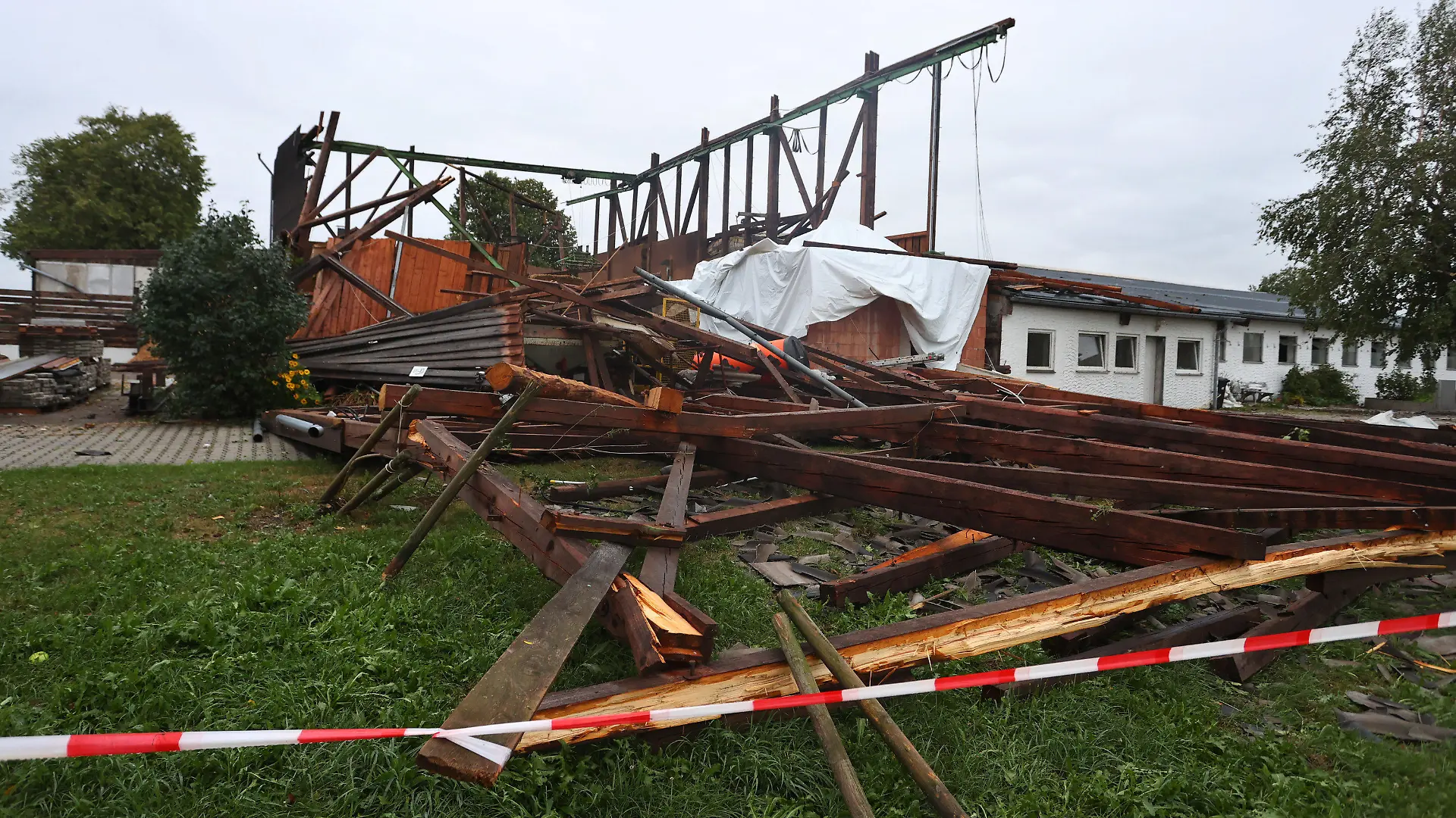 06.08.2022, Baden-Württemberg, Bad Wurzach: Die Überreste einer Lagerhalle stehen im Ortsteil Rohr. Bei einem Sturm wurde das Dach von der Materialhalle weggefegt. Es befindet sich nun 300 Meter von dem Gebäude entfernt, Foto: Karl-Josef Hildenbrand/dpa +++ dpa-Bildfunk +++
