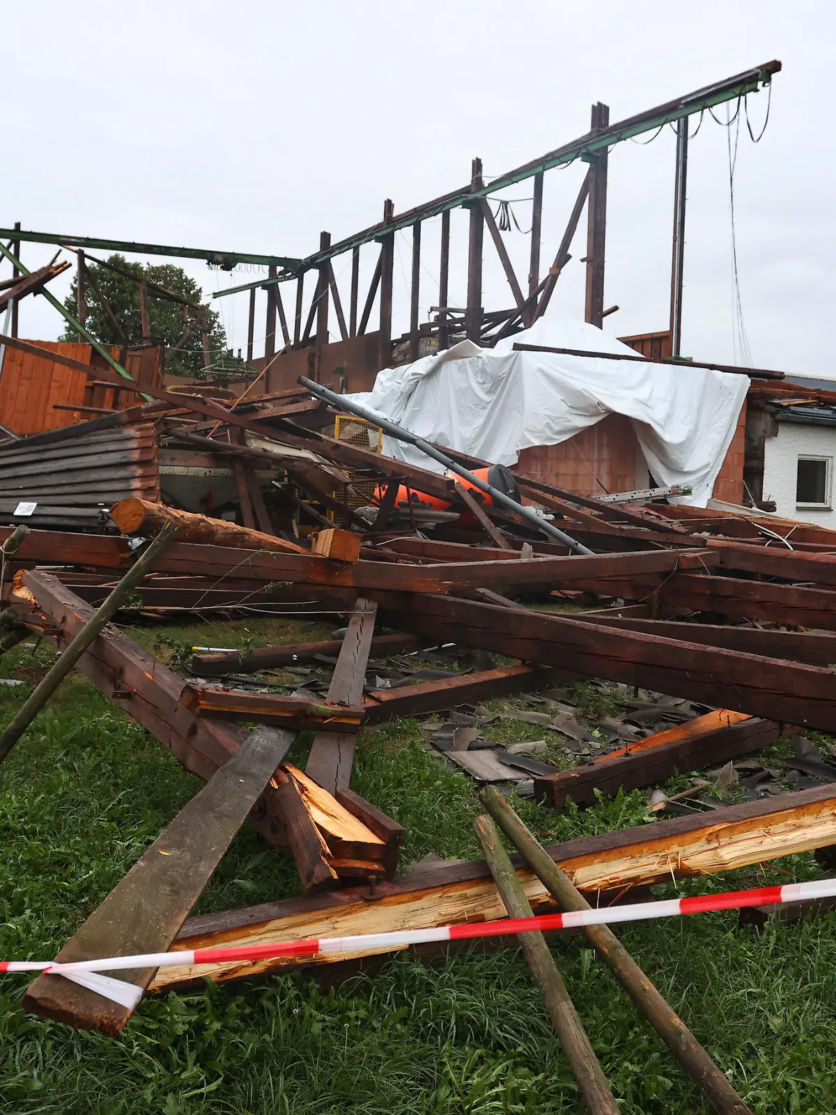 06.08.2022, Baden-Württemberg, Bad Wurzach: Die Überreste einer Lagerhalle stehen im Ortsteil Rohr. Bei einem Sturm wurde das Dach von der Materialhalle weggefegt. Es befindet sich nun 300 Meter von dem Gebäude entfernt, Foto: Karl-Josef Hildenbrand/dpa +++ dpa-Bildfunk +++