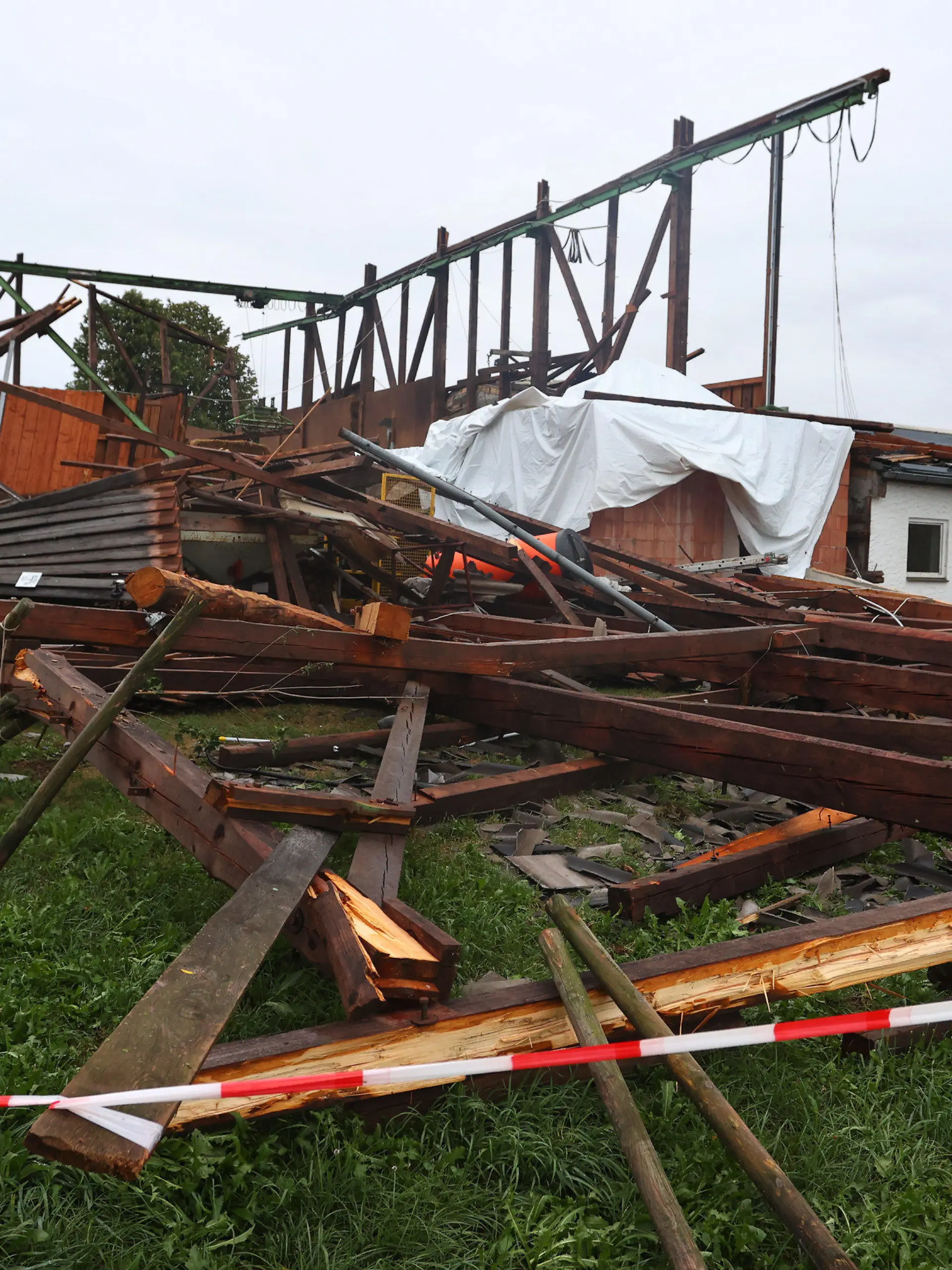06.08.2022, Baden-Württemberg, Bad Wurzach: Die Überreste einer Lagerhalle stehen im Ortsteil Rohr. Bei einem Sturm wurde das Dach von der Materialhalle weggefegt. Es befindet sich nun 300 Meter von dem Gebäude entfernt, Foto: Karl-Josef Hildenbrand/dpa +++ dpa-Bildfunk +++