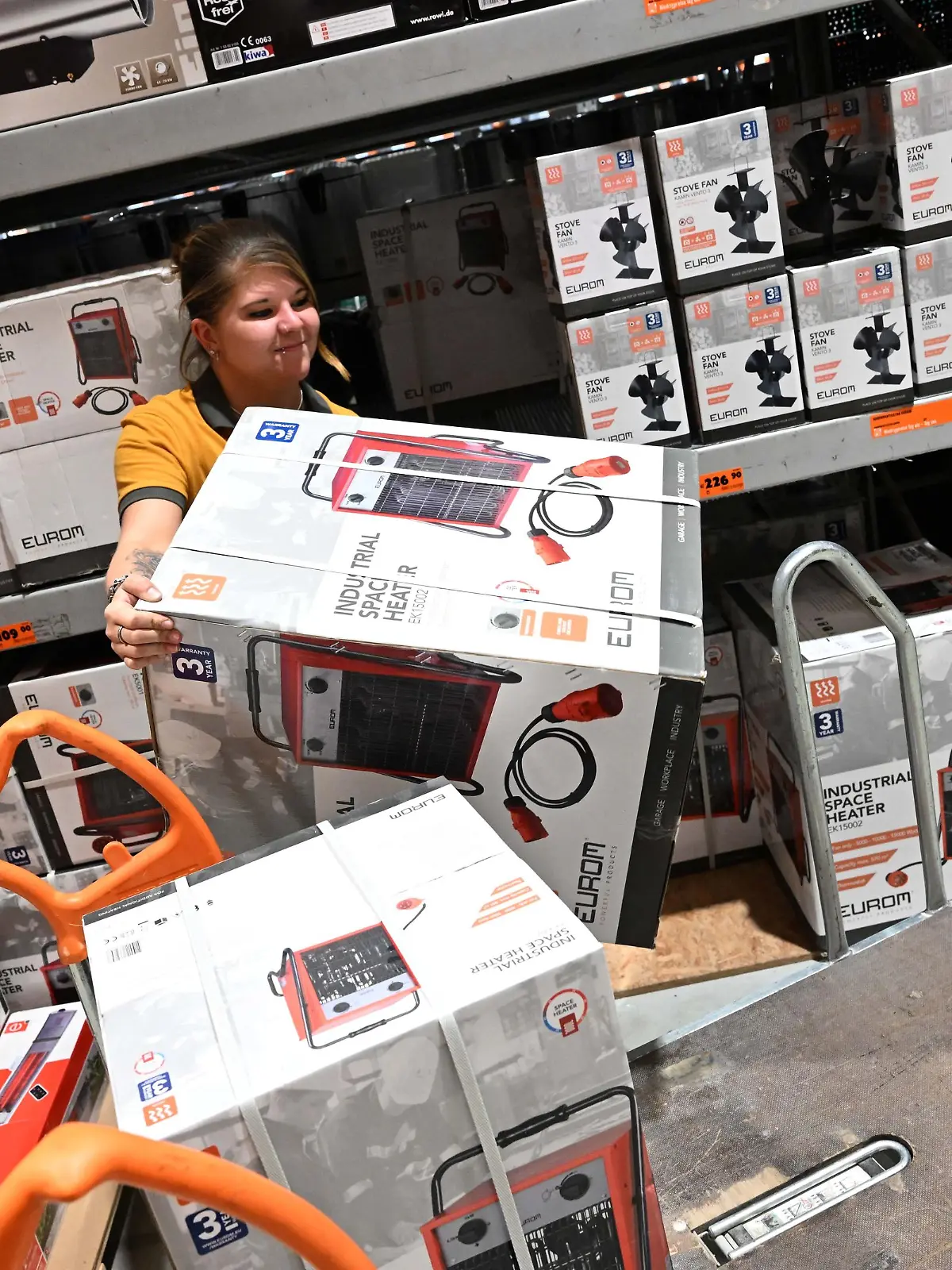 Jessica Bendorf, Mitarbeiterin bei Hornbach, räumt einen Heizlüfter aus einem Regal auf einen Wagen im Hornbach Baumarkt Fröttmaning. Die Angst vor Gas-Engpässen im kommenden Winter sorgt mitten im Sommer für einen Nachfrageboom bei Heizlüftern, Konvektorheizungen und Ölradiatoren.