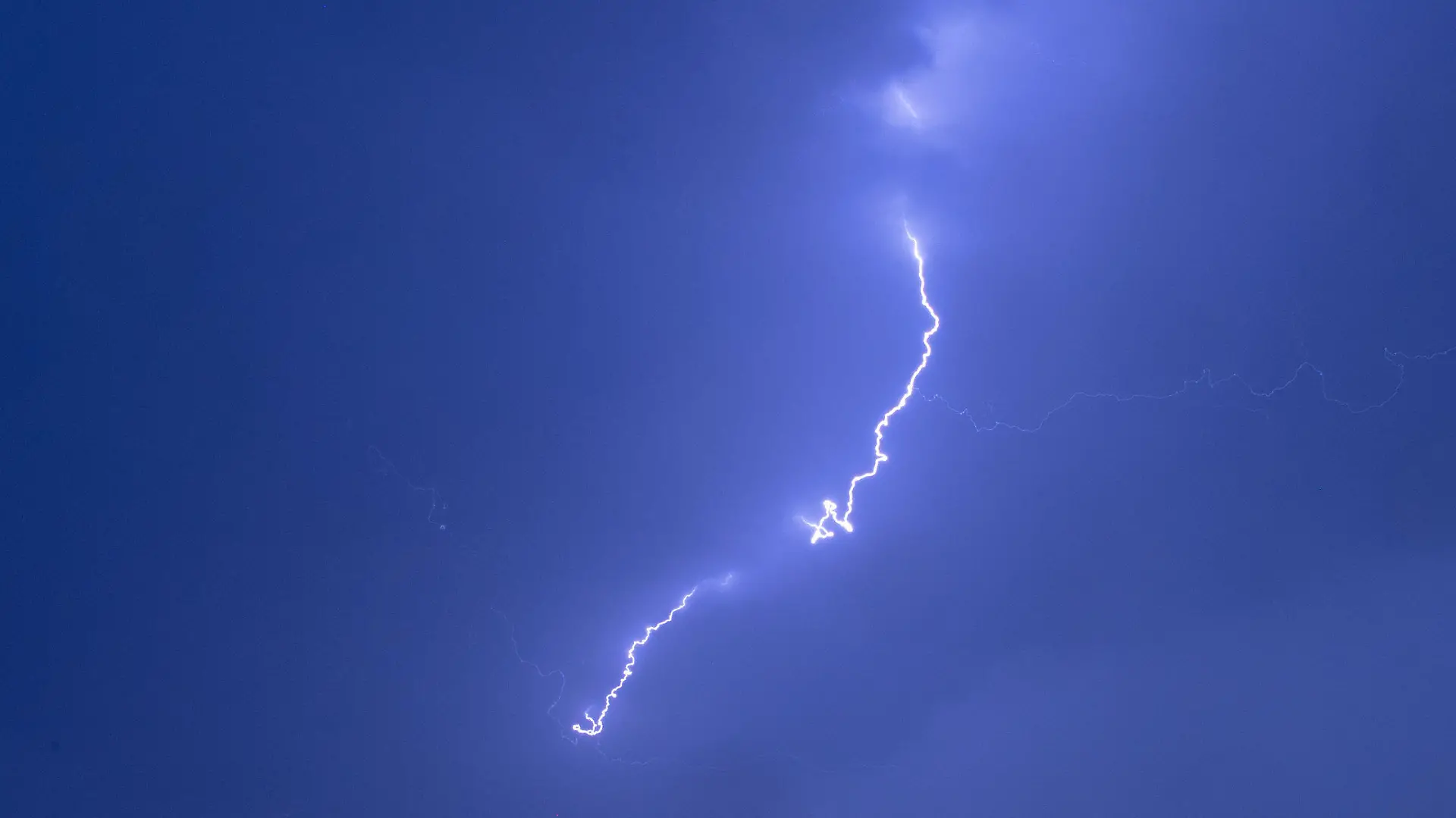 31.07.2019, Mecklenburg-Vorpommern, Pokrent: Ein Blitz ist bei einem starken Gewitter über einer Windkraftanlage zu sehen. Der Deutsche Wetterdienst hatte für Mecklenburg-Vorpommern vor örtlich starken Gewittern, teils mit Starkregen mit rund 20 Litern pro Quadratmeter in der Stunde gewarnt. Foto: Jens Büttner/dpa-Zentralbild/dpa +++ dpa-Bildfunk +++