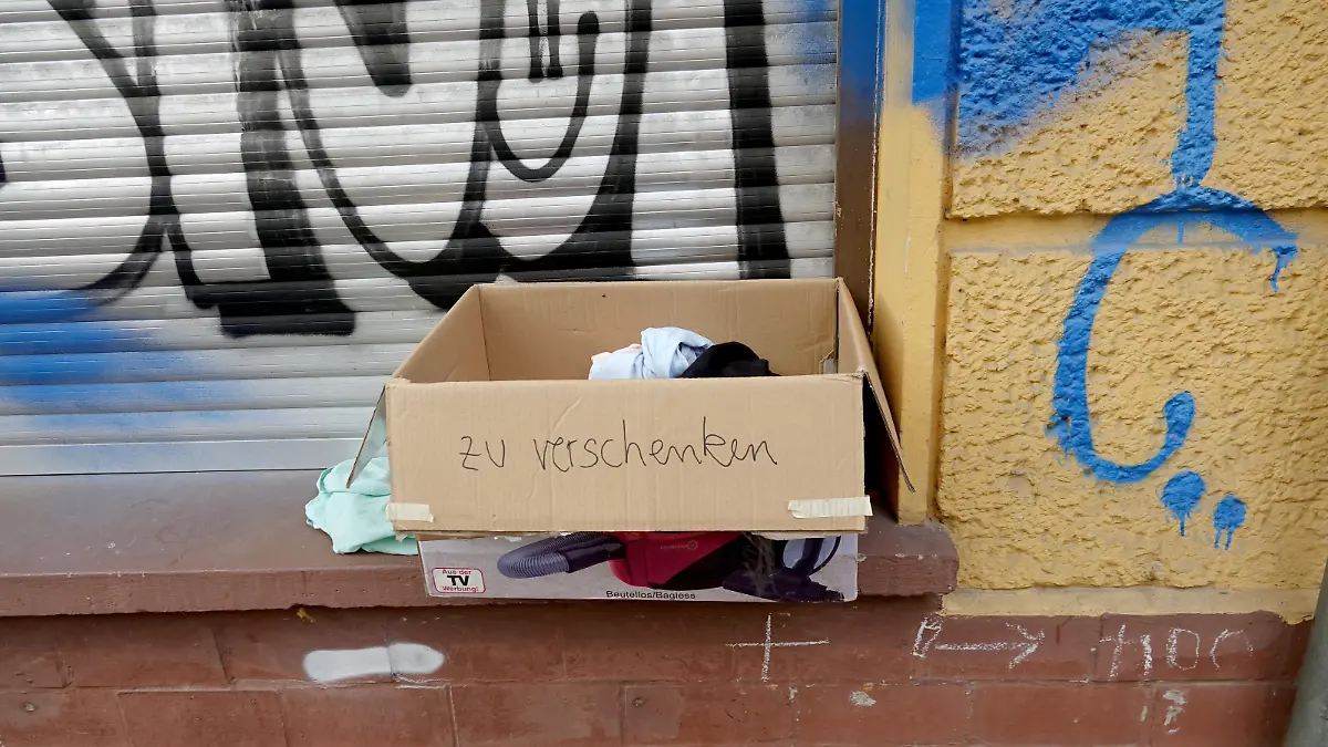 «Zu verschenken» steht auf einem Karton mit Kleidern, der auf einer Fensterbank steht.