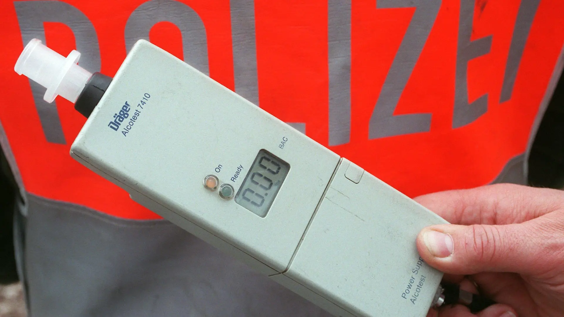 Potsdam (Brandenburg): Auf den Straßen sichtbar - die Polizei bei einer Verkehrskontrolle nahe Potsdam mit Alkoholmeßgerät. Seit dem 1. Mai 1998 gilt eine neue zusätzliche Promille-Grenze im Straßenverkehr, deren Einhaltung von der Polizei mit modernen High-Tech-Geräten zur Atemalkoholanalyse überwacht wird. Wer mit 0,5 Promille Alkohol im Blut am Steuer erwischt wird, muß zukünftig mit einem Bußgeld von 200 Mark und zwei Punkten in der Flensburger Verkehrssünderkartei rechnen. Ein Fahrverbot wird wie bisher erst ab einer Blutalkoholkonzentration von 0,8 Promille fällig. (PDM452-040598)