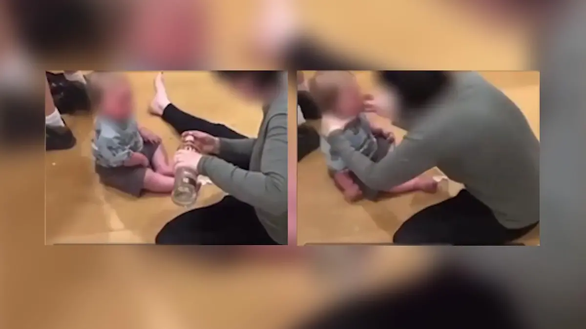 Im Video ist zu sehen, wie eine Frau einem kleinen Kind Wodka zu trinken gibt.