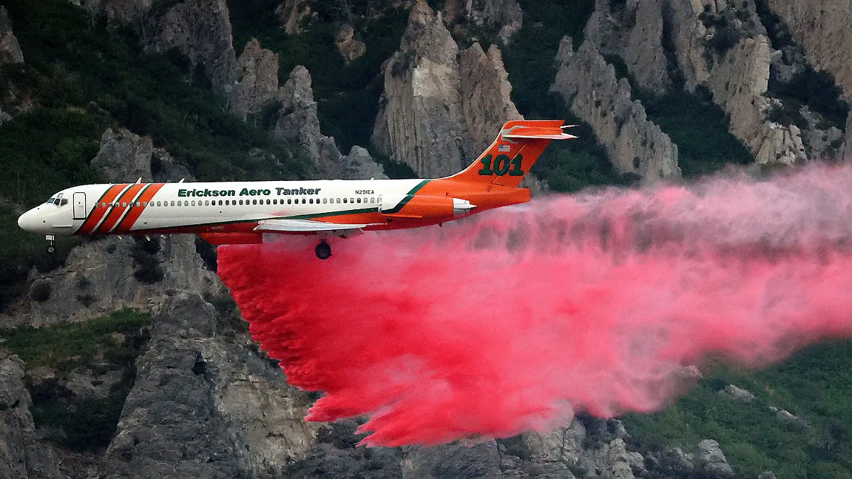 An Erickson Aero Tanker drops fire retardant over a wildfire in Springville on Monday, Aug. 1, 2022. A Utah man has been arrested on accusations he started a wildfire while trying to burn a spider with his lighter. A probable cause statement says 26-year-old Cory Allan Martin told deputies that he spotted the spider Monday while he was in a hiking area in the foothills south of Salt Lake City near the city of Springville. (Kristin Murphy/The Deseret News via AP)