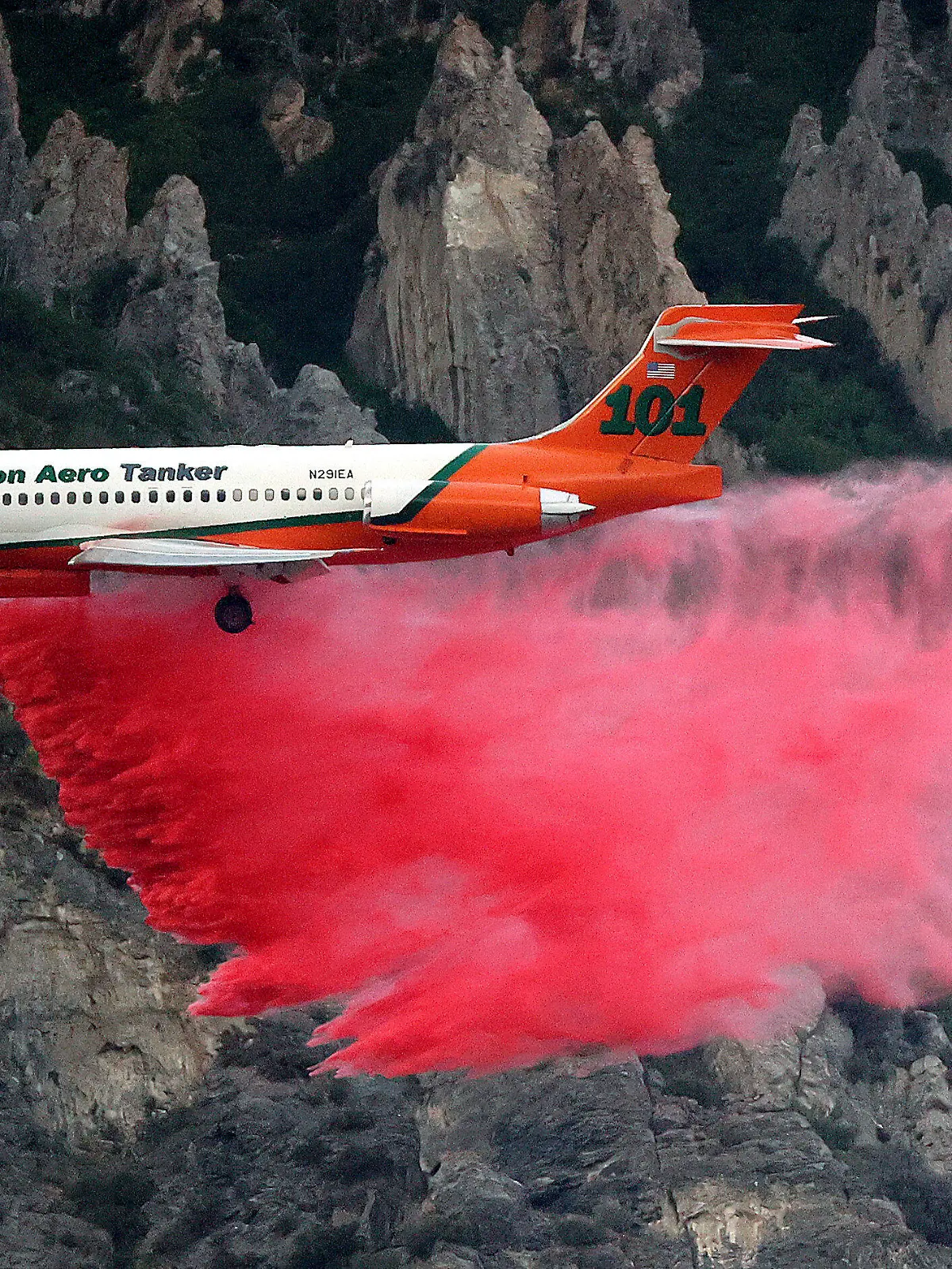 An Erickson Aero Tanker drops fire retardant over a wildfire in Springville on Monday, Aug. 1, 2022. A Utah man has been arrested on accusations he started a wildfire while trying to burn a spider with his lighter. A probable cause statement says 26-year-old Cory Allan Martin told deputies that he spotted the spider Monday while he was in a hiking area in the foothills south of Salt Lake City near the city of Springville. (Kristin Murphy/The Deseret News via AP)