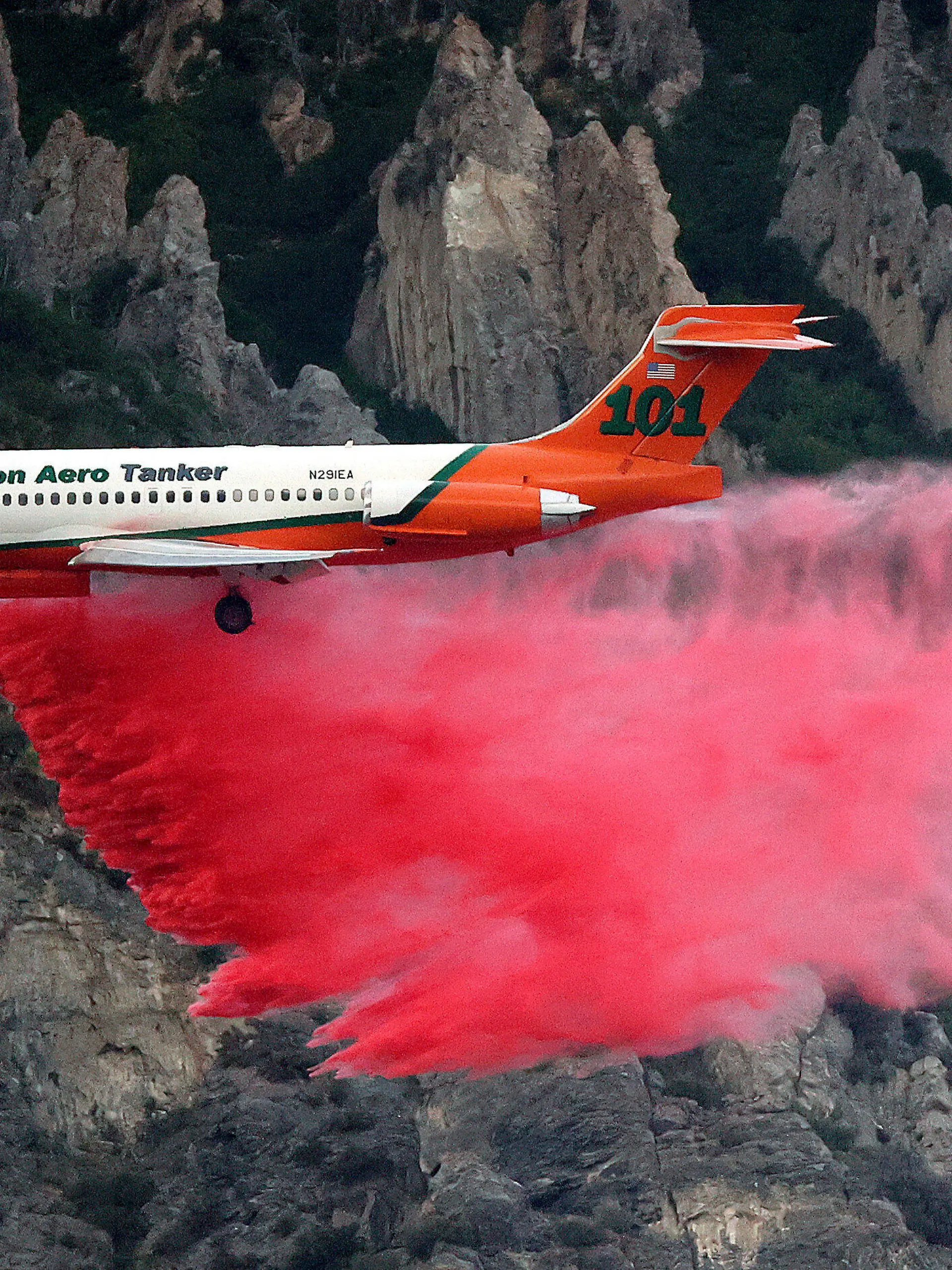 An Erickson Aero Tanker drops fire retardant over a wildfire in Springville on Monday, Aug. 1, 2022. A Utah man has been arrested on accusations he started a wildfire while trying to burn a spider with his lighter. A probable cause statement says 26-year-old Cory Allan Martin told deputies that he spotted the spider Monday while he was in a hiking area in the foothills south of Salt Lake City near the city of Springville. (Kristin Murphy/The Deseret News via AP)