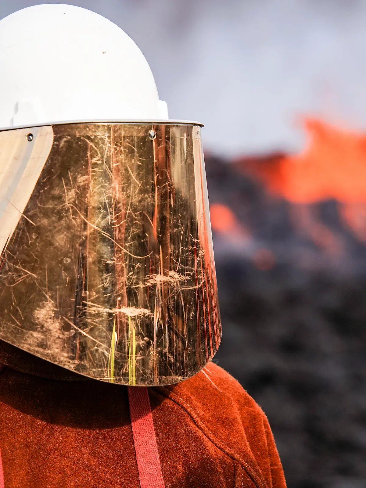 03.08.2022, Island, Keflavik: Eine Person trägt Schutzkleidung, als sie in der Nähe der Lava steht, die aus dem Vulkan Fagradalsfjall fließt. Auf Island hat ein erneuter Vulkanausbruch begonnen. Die erwartete Eruption habe in der Nähe des Bergs Fagradalsfjall auf der Reykjanes-Halbinsel südwestlich von Reykjavik begonnen, teilte die isländische Wetterbehörde am Mittwochnachmittag mit. Foto: Marco Di Marco/AP/dpa +++ dpa-Bildfunk +++