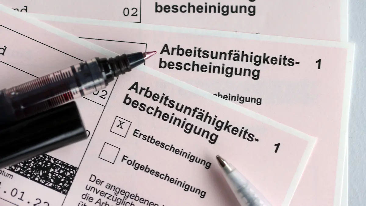ARCHIV - 14.01.2022, Schleswig-Holstein, Kiel: Stifte liegen auf den Arbeitsunfähigkeitsbescheinigungen für Arbeitnehmer im Falle einer Krankschreibung durch den Arzt. (zu dpa: «Fehlzeiten wegen psychischer Erkrankungen im Norden gestiegen») Foto: Jens Büttner/dpa-Zentralbild/dpa +++ dpa-Bildfunk +++