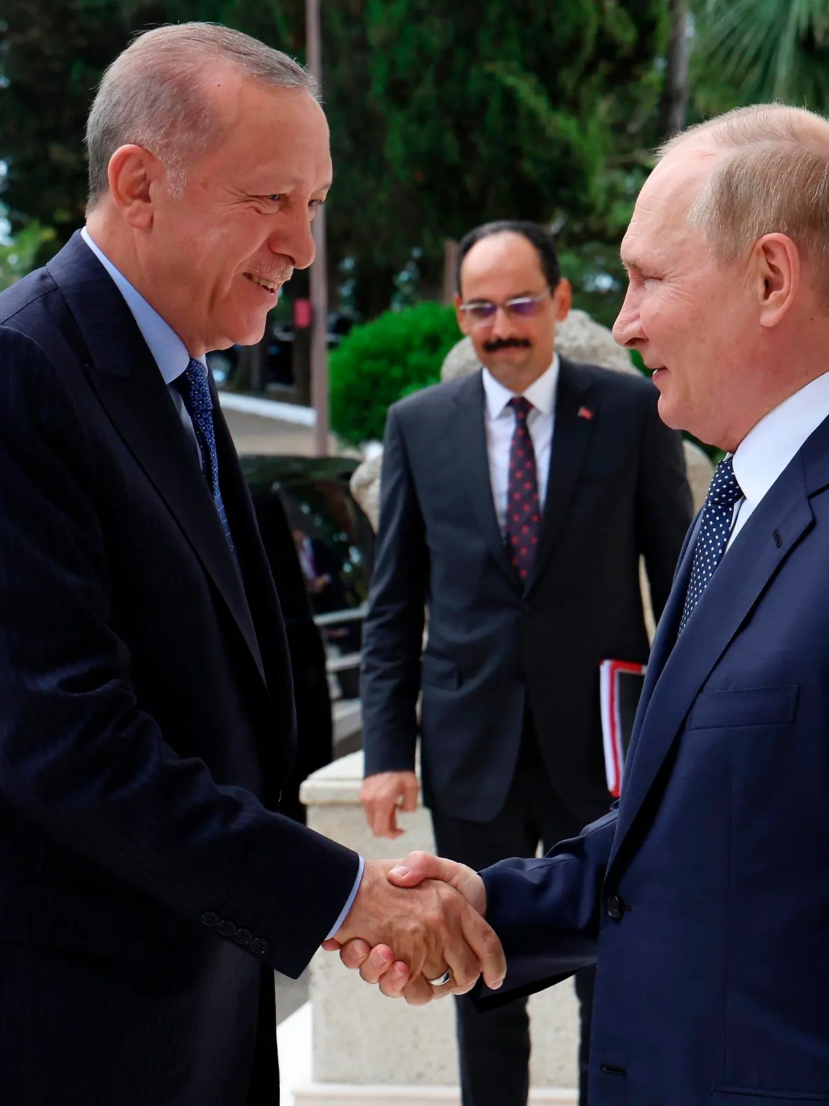 Russian President Vladimir Putin, right, greets Turkish President Recep Tayyip Erdogan upon his arrival at the Rus sanatorium in the Black Sea resort of Sochi, Russia, Friday, Aug. 5, 2022. Erdogan's spokesman Ibrahim Kalin is the center. Turkish President Recep Tayyip Erdogan traveled to Russia Friday for talks with Russian President Vladimir Putin expected to focus on a grain deal brokered by Turkey, prospects for talks on ending hostilities in Ukraine, and the situation in Syria. (Vyacheslav Prokofyev, Sputnik, Kremlin Pool Photo via AP)