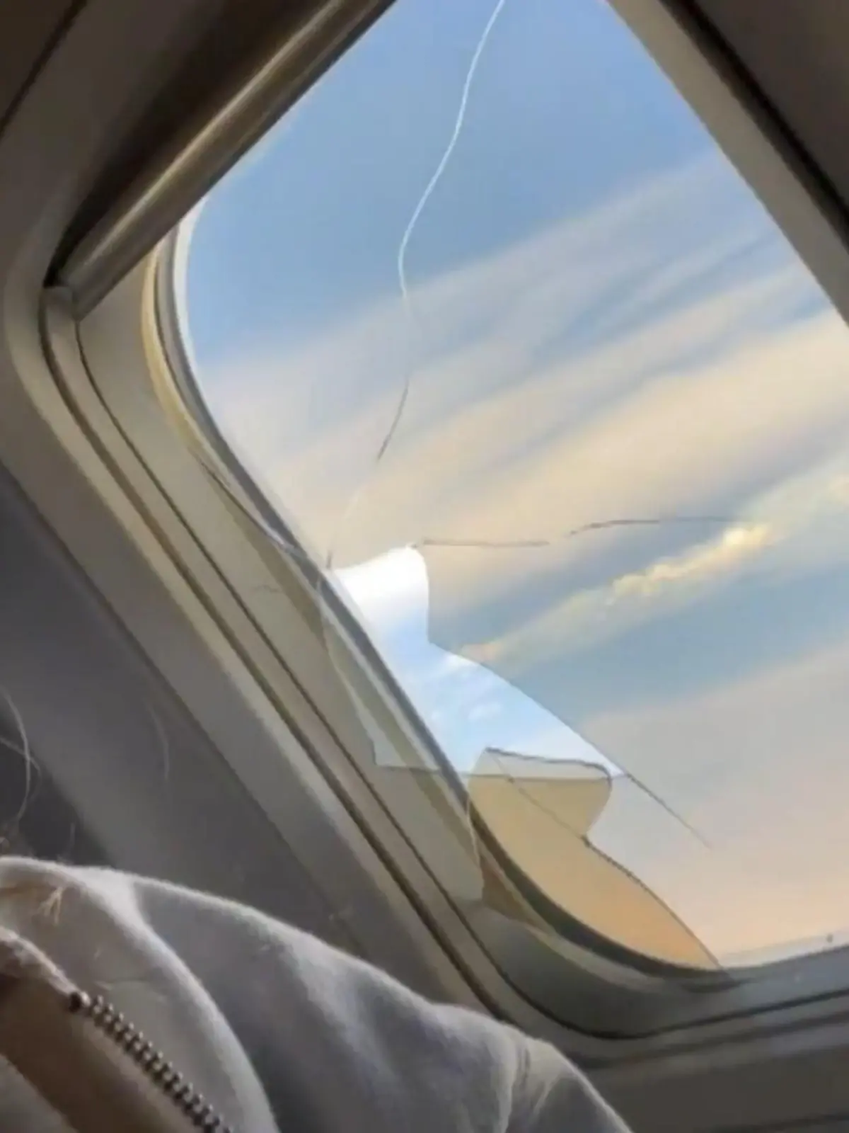 Auf TikTok hat eine junge Frau ein zerbrochenes Fenster im Flugzeug gefilmt.