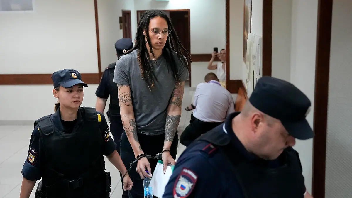WNBA star and two-time Olympic gold medalist Brittney Griner is escorted in a court room prior to a hearing, in Khimki just outside Moscow, Russia, Thursday, Aug. 4, 2022. Closing arguments in Brittney Griner's cannabis possession case are set for Thursday, nearly six months after the American basketball star was arrested at a Moscow airport in a case that reached the highest levels of US-Russia diplomacy. (AP Photo/Alexander Zemlianichenko)