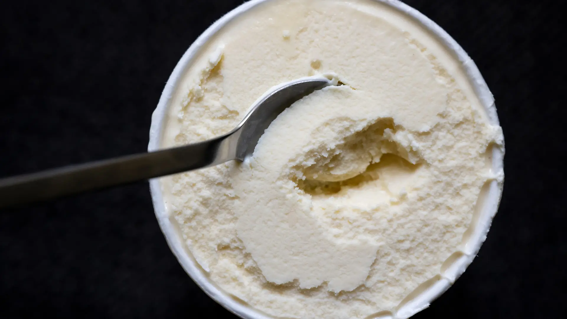Ein Löffel steckt in einem Becher mit Vanilleeis. Der Hersteller General Mills ruft Produkte von Häagen-Dazs mit der Geschmacksrichtung «Vanilla» zurück. Es könne nicht ausgeschlossen werden, dass sich in den Produkten Rückstände von Ethylenoxid befinden. Es gehe um die Größen 460 ml, 95 ml und die Classic Collection 4x95 ml mit dem Mindesthaltbarkeitsdatum 21. Mai 2023.