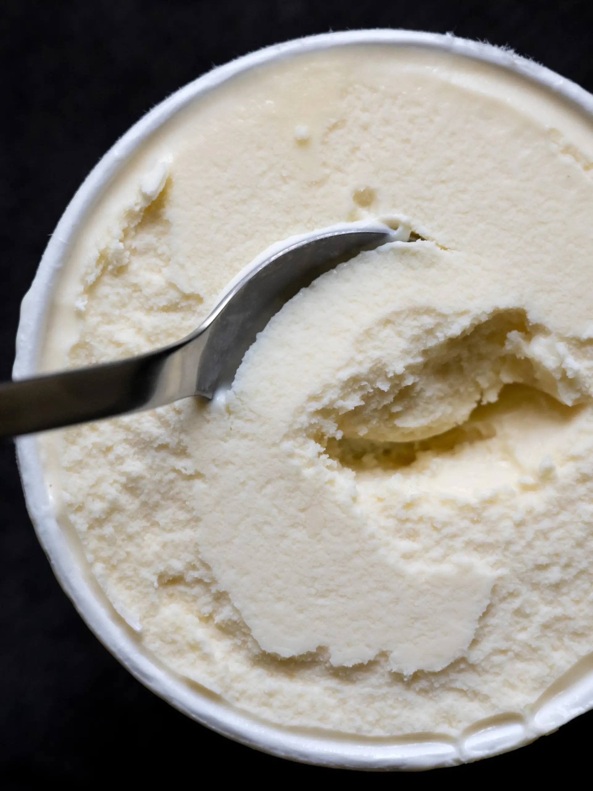 Ein Löffel steckt in einem Becher mit Vanilleeis. Der Hersteller General Mills ruft Produkte von Häagen-Dazs mit der Geschmacksrichtung «Vanilla» zurück. Es könne nicht ausgeschlossen werden, dass sich in den Produkten Rückstände von Ethylenoxid befinden. Es gehe um die Größen 460 ml, 95 ml und die Classic Collection 4x95 ml mit dem Mindesthaltbarkeitsdatum 21. Mai 2023.