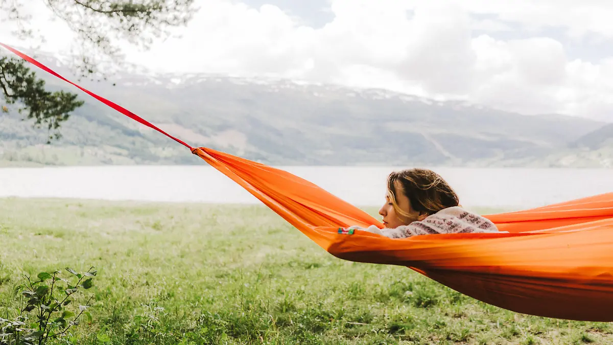 Young caucasian woman  in hammock on the background of fjord in Norway