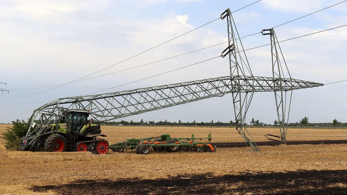 04.08.2022, Nordrhein-Westfalen, Weilerswist: Ein 16 Jahre alter Landwirt hat mit seinem Traktor den Mast einer Hochspannungsleitung umgeknickt und so einen großflächigen Stromausfall mit Zehntausenden Betroffenen verursacht. Teile der Kreise Euskirchen und Düren sowie des Rhein-Erft- und Rhein-Sieg-Kreises seien ohne Strom, sagte eine Sprecherin des Verteilnetzbetreibers Westnetz am Donnerstag. (zu dpa «16-jähriger Bauer fährt mit Traktor Mast um - Zehntausende ohne Strom») Foto: Thomas Schmitz/Kölner Stadt-Anzeiger Medien/dpa +++ dpa-Bildfunk +++