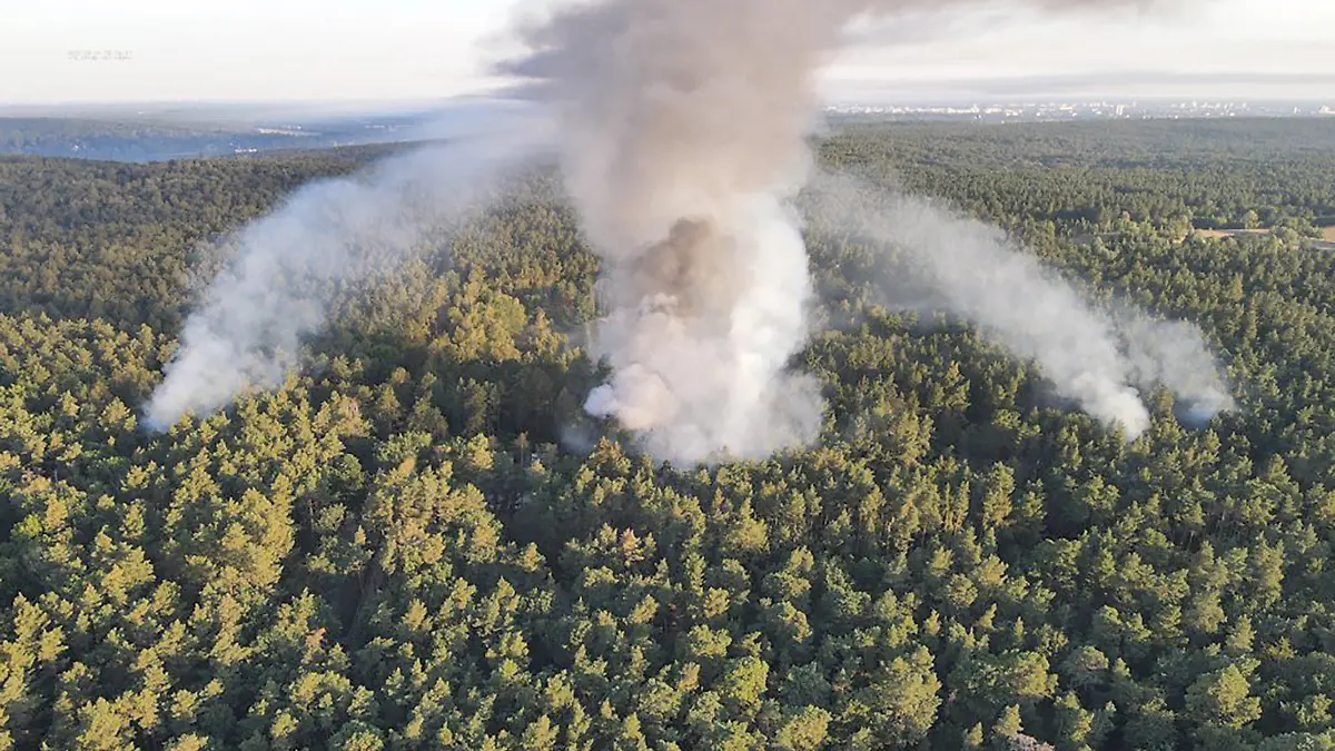 HANDOUT - 04.08.2022, Berlin: Die Luftaufnahme der Berliner Feuerwehr zeigt den Brand im Grunewald. Im Berliner Grunewald ist nach einer unbeabsichtigten Explosion auf dem dortigen Sprengplatz am Donnerstagmorgen ein Feuer ausgebrochen und hat den angrenzenden Wald in Brand gesetzt. Foto: -/Berliner Feuerwehr/dpa - ACHTUNG: Nur zur redaktionellen Verwendung im Zusammenhang mit der aktuellen Berichterstattung und nur mit vollständiger Nennung des vorstehenden Credits +++ dpa-Bildfunk +++