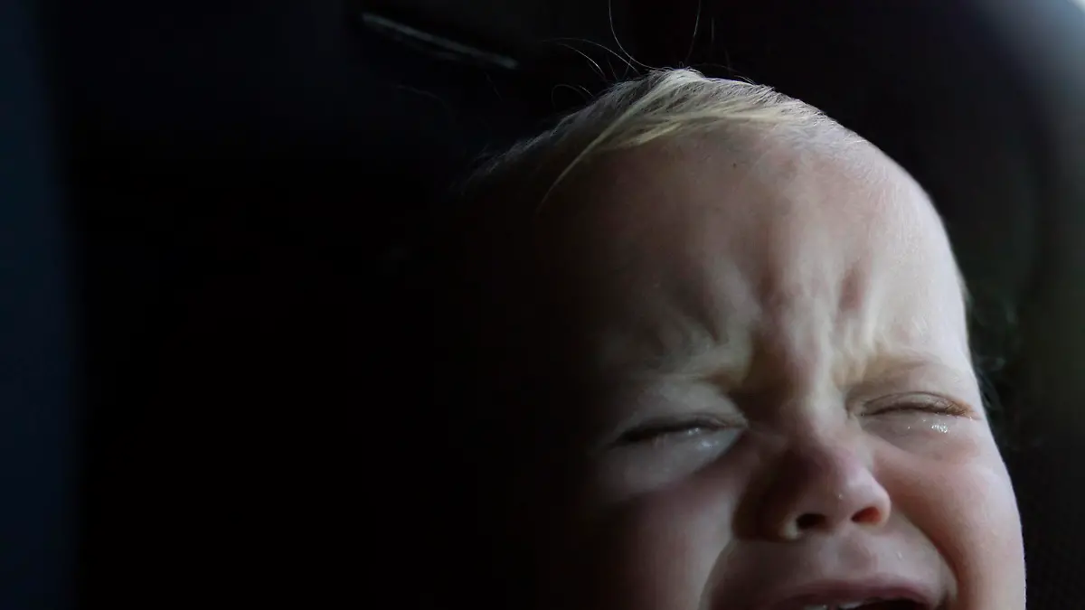 A 12 month ld baby boy crying in his car seat.