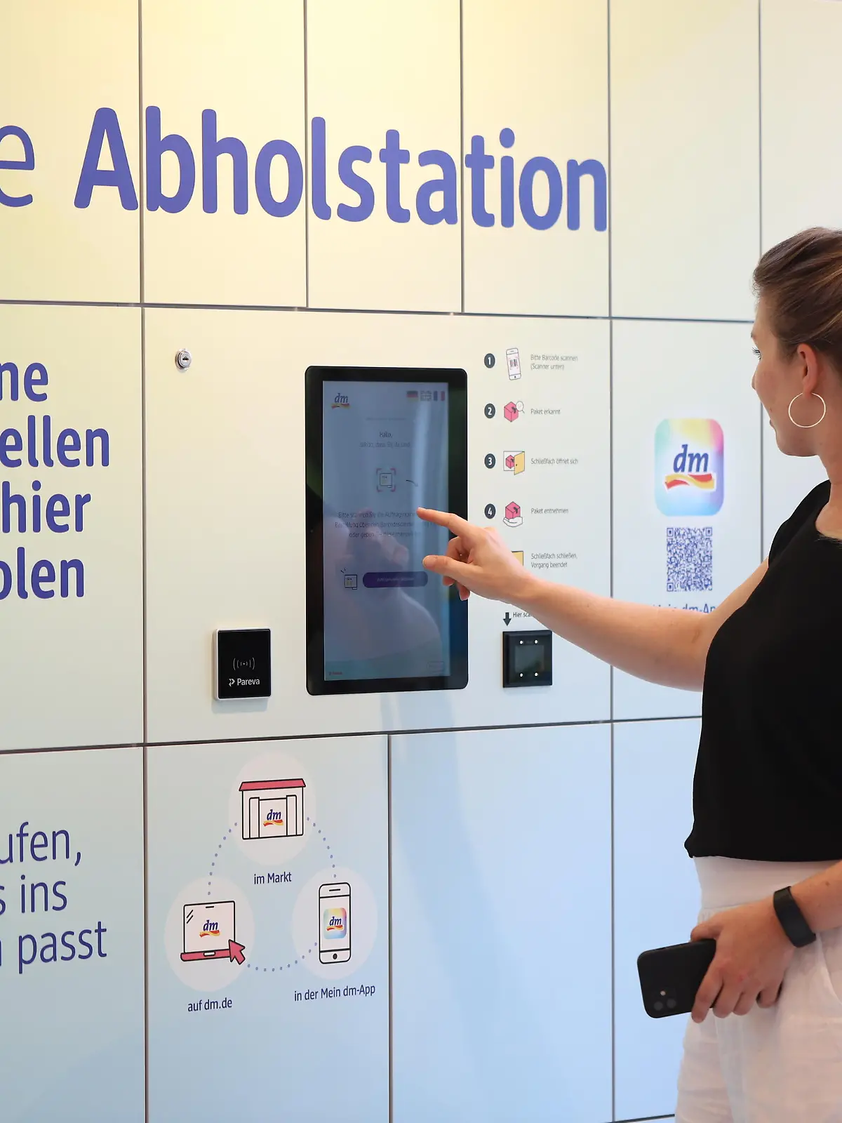 Kundin holt bestellte Waren an der Station in der dm-Filiale ab