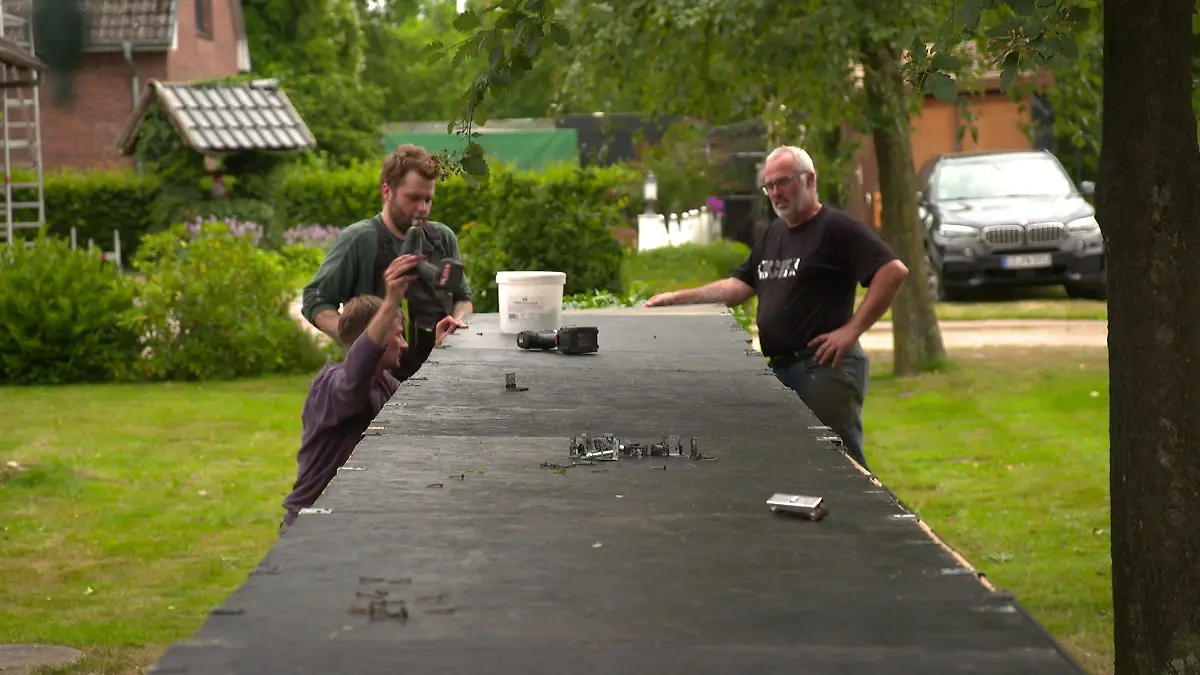 Dorfbewohner bauen im Vorgarten einen Tresen zum Verkaufen auf.