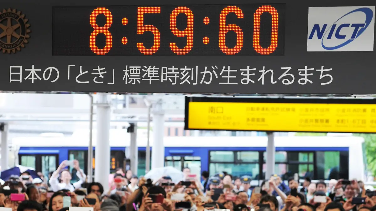 People take a photo of a digital clock displaying a leap second at a train station in the western Tokyo suburb of Koganei, eastern Japan, Wednesday, July 1, 2015. About 200 people waited for the moment when the clock displayed "8:59:60" (eight hours, 59 minutes, 60 seconds) to indicate the insertion of a leap second. The clock turned from "8:59:59" to "8:59:60" and then "9:00:00."
