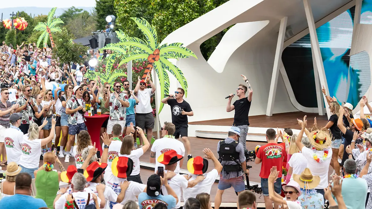 dpatopbilder - 31.07.2022, Rheinland-Pfalz, Mainz: Das Publikum feiert den Auftritt des Schlager-Duos DJ Robin & Schürze mit dem umstrittenen Song «Layla» im «ZDF-Fernsehgarten». Seit Wochen gibt es eine Sexismus-Debatte um ihr Lied. Der «Fernsehgarten» stand am Sonntag unter dem Partymotto «Mallorca vs. Oktoberfest». Foto: Hannes P. Albert/dpa +++ dpa-Bildfunk +++