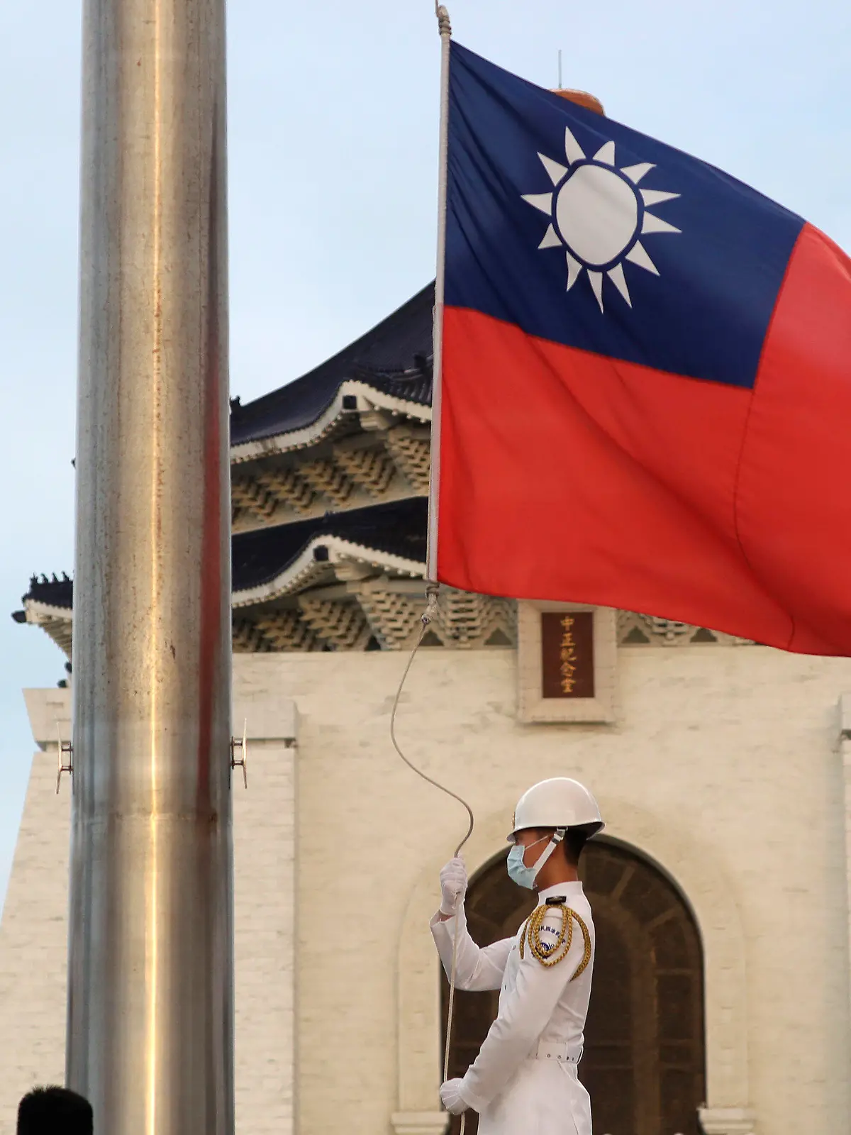 30.07.2022, Taiwan, Taipei: Zwei Soldaten senken die Nationalflagge während der täglichen Flaggenzeremonie auf dem Freiheitsplatz der Chiang Kai-shek Memorial Hall. (zu dpa: Nach Warnung aus China: Mögliche Taiwan-Reise Pelosis weiter offen) Foto: Chiang Ying-Ying/AP/dpa +++ dpa-Bildfunk +++