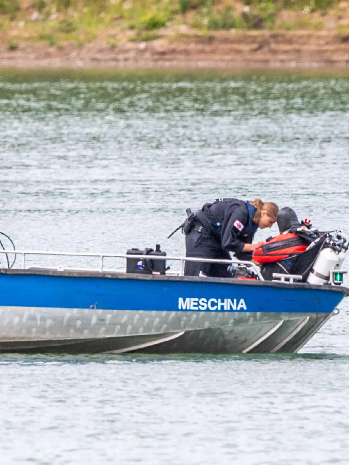 27.07.2022, Nordrhein-Westfalen, Porta Westfalica: Ein Polizeiboot mit Tauchern der Taucheinheit Bochum liegt an einer vom Sonar markierten und betonnten Stelle auf einem Kiesteich, an dem am Sonntag (24.07.2022) aus ungeklärten Gründen beim Baden zwei Personen nicht mehr aufgetaucht sind. Laut einem Sprecher der Feuerwehr sind manche Stellen des Sees rund 30 Meter tief. Fachleute der Polizei wollen nun mit einer Unterwassersonde nach den zwei Personen suchen. Foto: Lino Mirgeler/dpa +++ dpa-Bildfunk +++