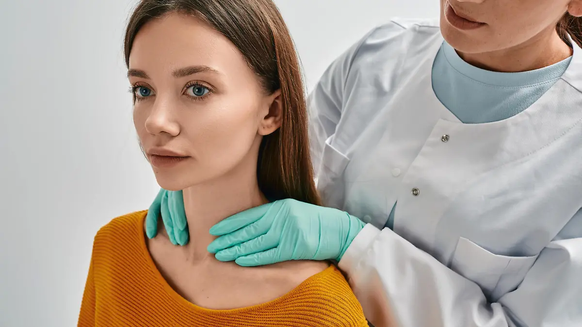 Endocrinologist checking thyroid gland of adult female patient by palpation. Woman has enlarged thyroid gland and hormones are not normal