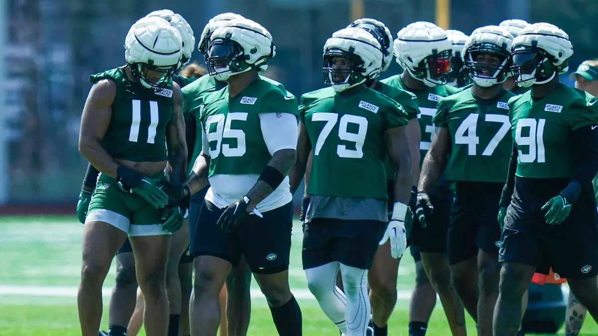 New York Jets' Jermaine Johnson (11), left, and Quinnen Williams (95), second from left, talk during practice at the NFL football team's training facility in Florham Park, N.J., Sunday, July 23, 2023. (AP Photo/Seth Wenig)