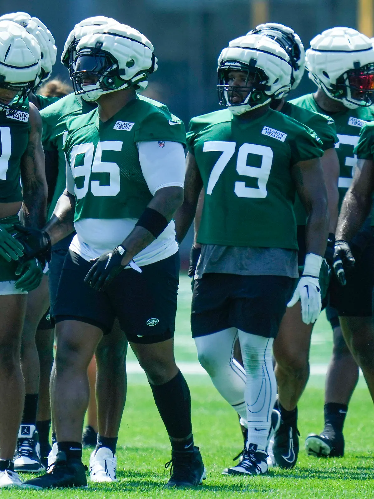 New York Jets' Jermaine Johnson (11), left, and Quinnen Williams (95), second from left, talk during practice at the NFL football team's training facility in Florham Park, N.J., Sunday, July 23, 2023. (AP Photo/Seth Wenig)