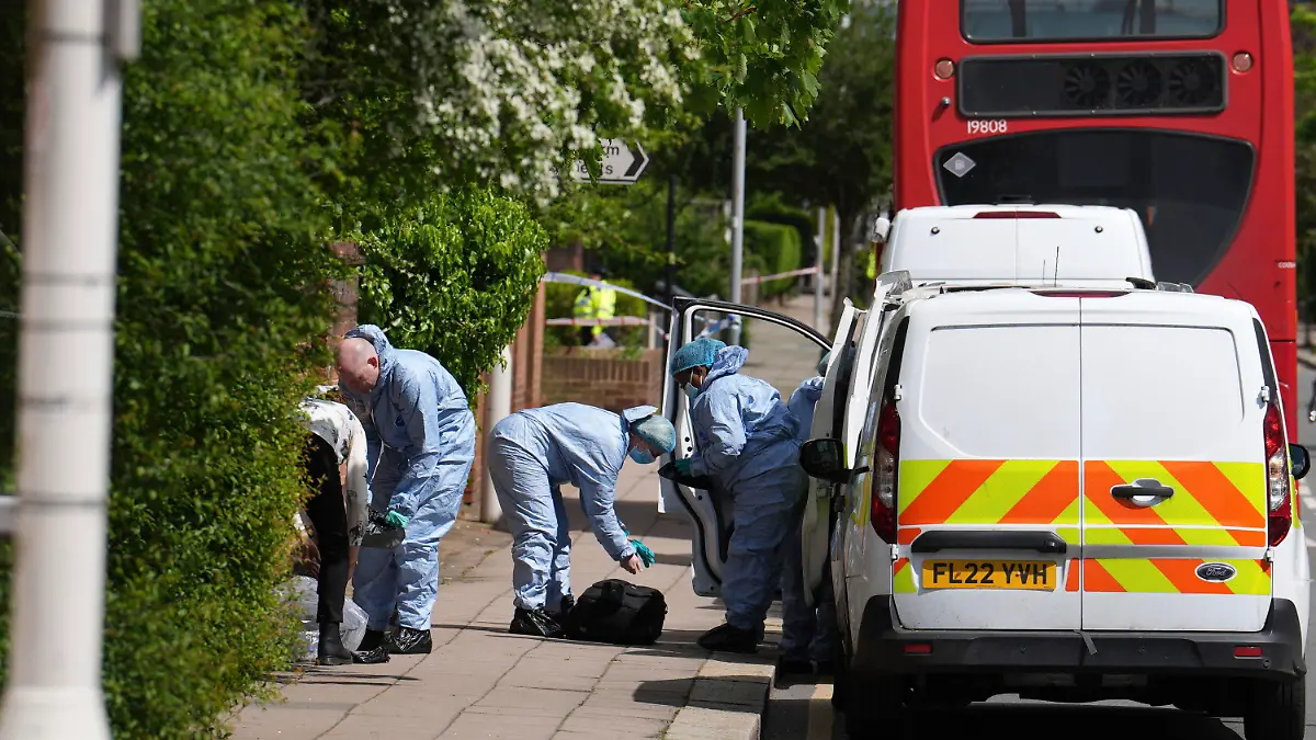 Forensic investigators in Hainault, north east London, Tuesday April 30, 2024. A man wielding a sword attacked members of the public and police officers in a east London suburb, killing a 13-year-old boy and injuring four others, authorities said Tuesday. A 36-year-old man was arrested at the scene, police said. Chief Supt. Stuart Bell said the incident is not being treated as terror-related or a “targeted attack.” (Jordan Pettitt/PA via AP)