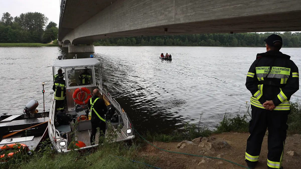23.05.2022, Bayern, Großmehring: Rettungskräfte stehen am Ufer der Donau. Einige Kilometer flussabwärts wurde vor wenigen Tagen eine Kinderleiche aus dem Fluss geborgen. Wie die Polizei am Montag berichtete, habe die rechtsmedizinische Untersuchung ergeben, dass es sich um einen Jungen im Vorschulalter handele. Die Identität und die Todesursache seien noch unklar. Am Montag suchten Einsatzkräfte den Bereich erneut ab. Foto: Friedrich/vifogra/dpa +++ dpa-Bildfunk +++
