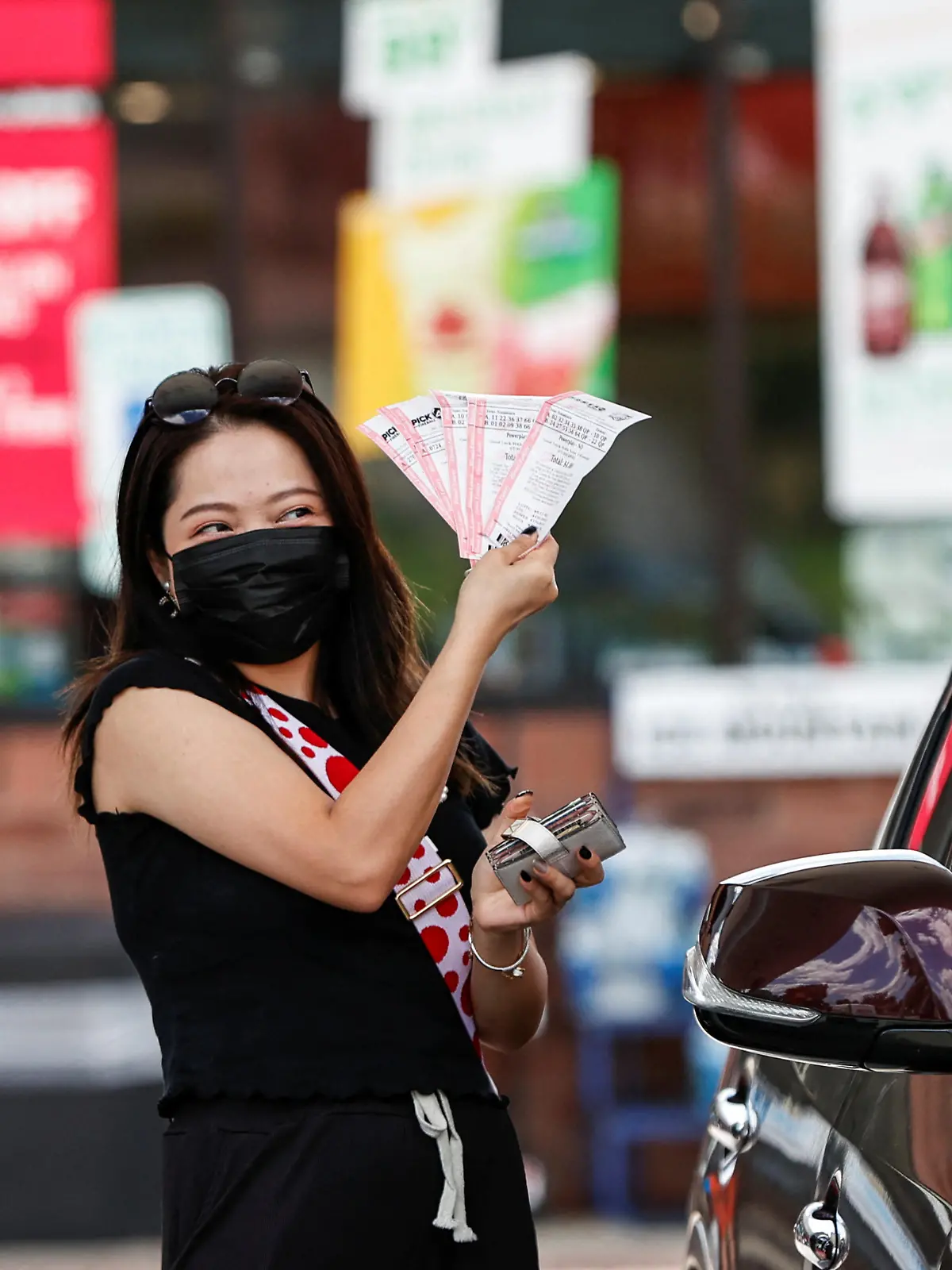 Customer Angelina Weng shows her purchased lottery tickets outside the Speedway gas station, where the winning ticket for the Mega Millions lottery jackpot was sold, in Des Plaines, Illinois, U.S. July 30, 2022. REUTERS/Kamil Krzaczynski