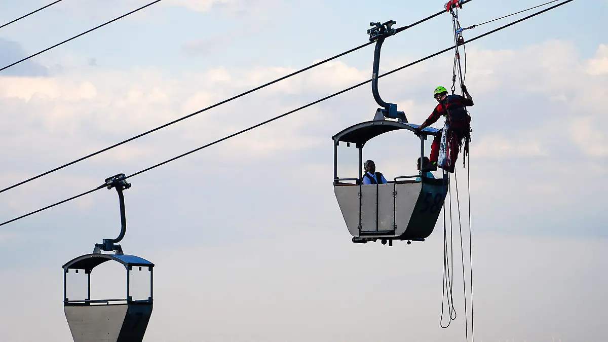 dpatopbilder - 29.07.2022, Hessen, Rüdesheim am Rhein: Höhenretter sind an einer stehengebliebenen Seilbahn an einer Gondel mit Passagieren im Einsatz. Rettungskräfte haben am Freitagabend 41 Menschen aus den Gondeln der Seilbahn Rüdesheim in Hessen befreit. Die knapp 1,4 Kilometer lange Bahn war zuvor wegen eines technischen Defekts an der Hydraulik stehengeblieben, wie ein Polizeisprecher sagte. Die Fahrgäste waren fast drei Stunden lang in den bis zu 14 Meter über der Erde hängenden Gondeln gefangen. Insgesamt wurden 41 Passagiere aus 20 Gondeln gerettet. Verletzt wurde bei dem Vorfall niemand. Foto: -/5vision.Media/dpa +++ dpa-Bildfunk +++