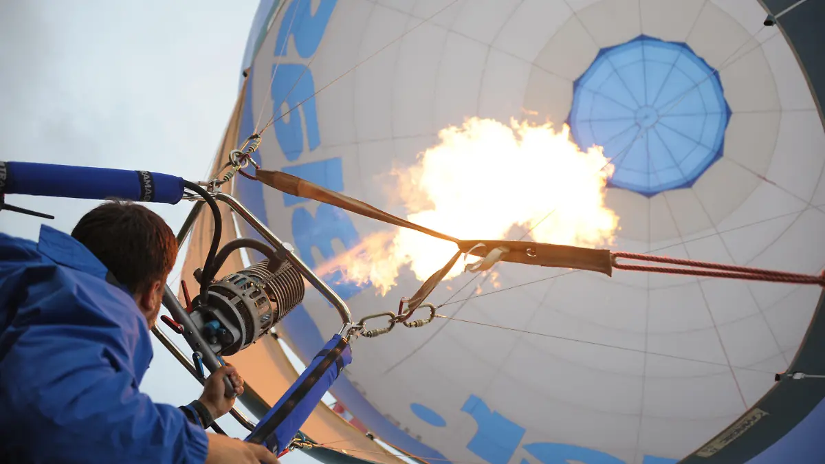 27.09.2019, Baden-Württemberg, Pforzheim: Ballonfahrer David Strasmann heizt kurz vor dem Start seines Heißluftballons bei der Deutschen Meisterschaft für Heißluftballone die Luft in seinem Ballon auf. Mehr als 50 Teams verschiedener Nationen treffen sich zu dem Heißluftballon-Festival. Starke Windböen hatten zunächst den Start behindert. Ein für den frühen Morgen geplanter Massenstart vom Buckenberg fiel aus. Am frühen Abend konnten die Ballone dann aber doch aufsteigen. (zu dpa "Wind bremst Heißluftballon-Wettbewerb über Pforzheim") Foto: Gregor Bauernfeind/dpa +++ dpa-Bildfunk +++