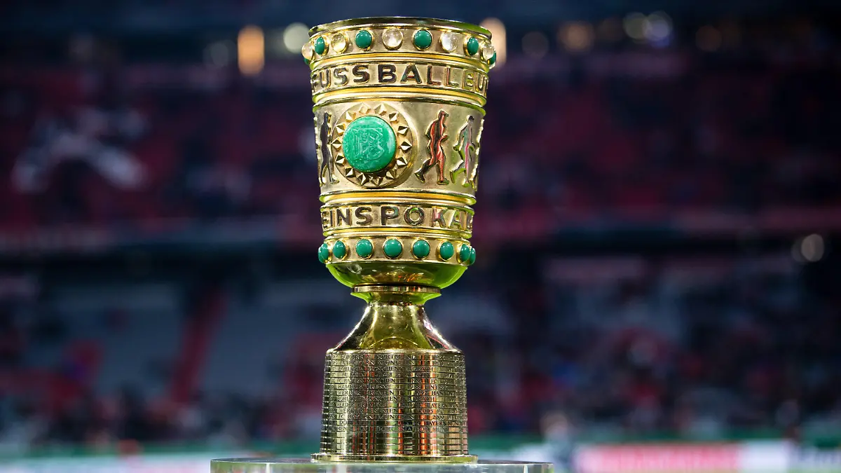 ARCHIV - 05.02.2020, Bayern, München: Fußball: DFB-Pokal, Bayern München - 1899 Hoffenheim, Achtelfinale in der Allianz Arena. Der DFB-Pokal steht vor Spielbeginn während eines Interviews am Spielfeldrand. (zu dpa «Pokal als Cup der Außenseiter - Duell der Andersdenkenden in Berlin») Foto: Matthias Balk/dpa - WICHTIGER HINWEIS: Gemäß den Vorgaben der DFL Deutsche Fußball Liga bzw. des DFB Deutscher Fußball-Bund ist es untersagt, in dem Stadion und/oder vom Spiel angefertigte Fotoaufnahmen in Form von Sequenzbildern und/oder videoähnlichen Fotostrecken zu verwerten bzw. verwerten zu lassen. +++ dpa-Bildfunk +++