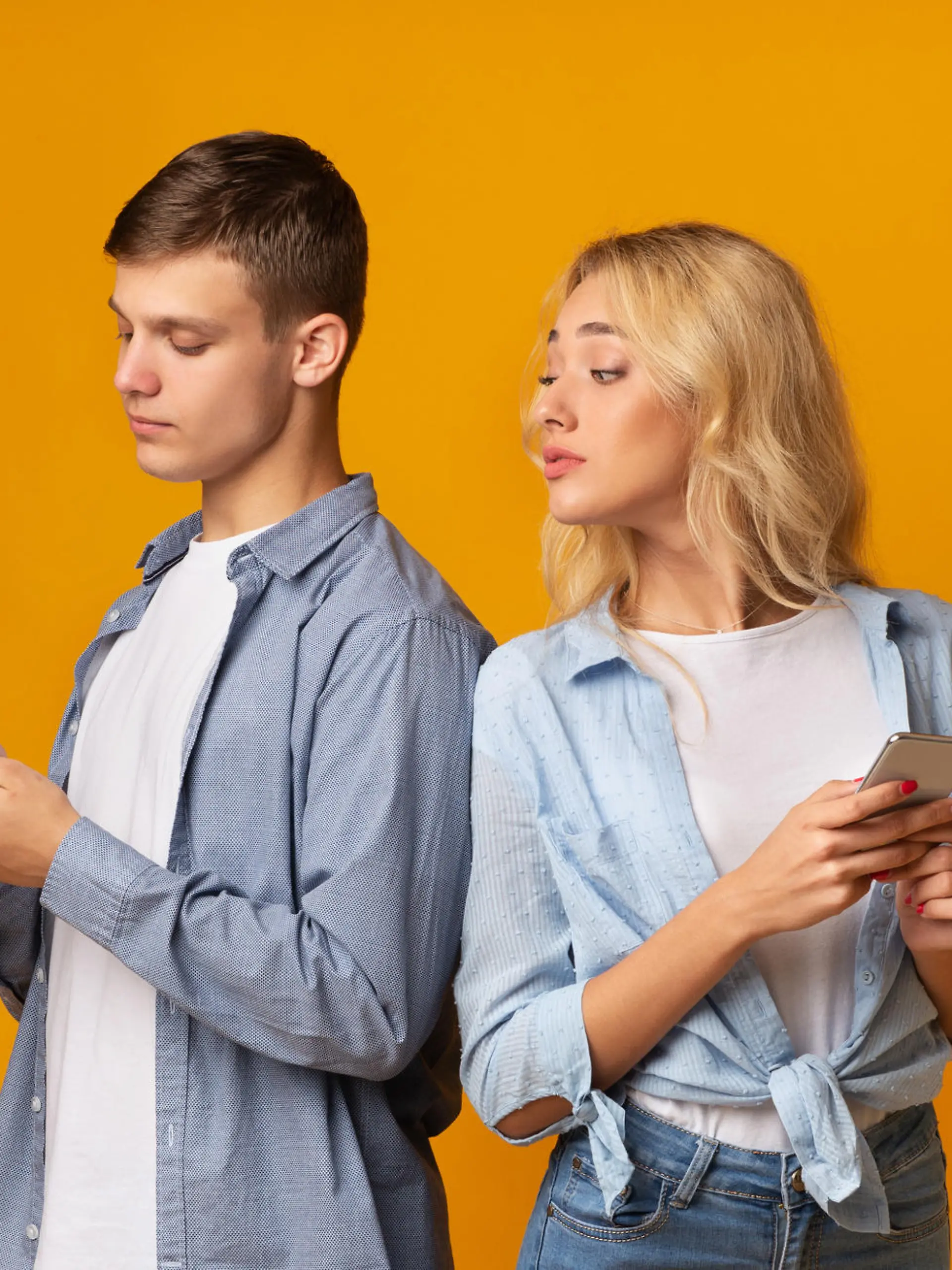 Mistrust concept. Curious young girl peeking over shoulder how her boyfriend texting on phone, panorama with free space