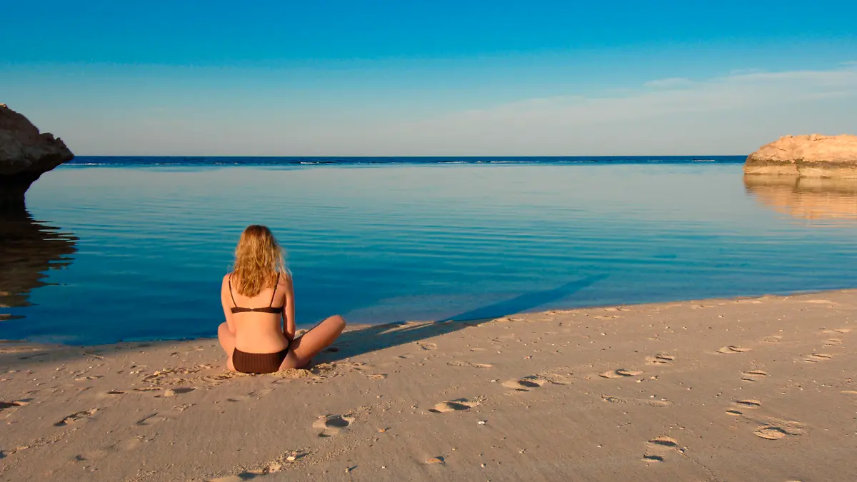 Junge Frau sitzt am Meer, Hurghada, Aegypten, Afrika