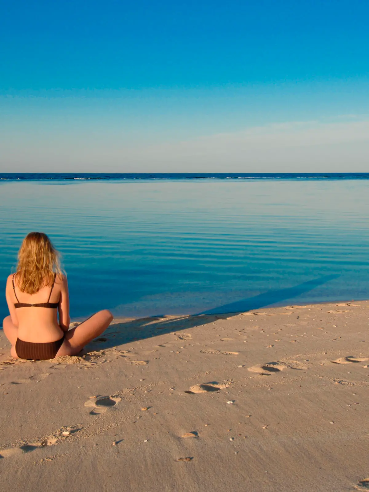 Junge Frau sitzt am Meer, Hurghada, Aegypten, Afrika