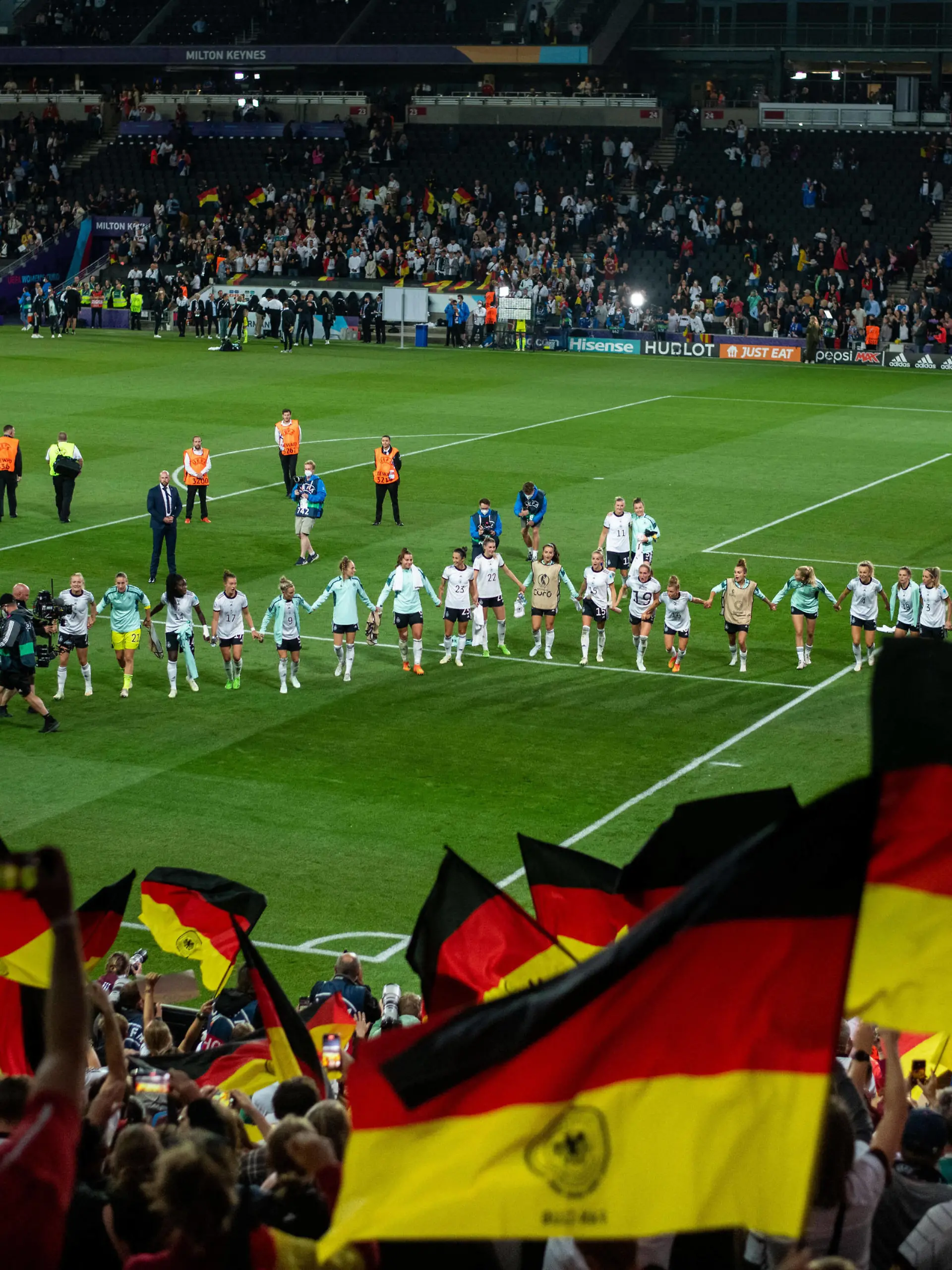 Sport Bilder des Tages Die Spielerinnen von Deutschland jubeln ueber den Sieg, davor die Fans auf der Tribuene mit Fahnen, GBR, Deutschland vs. Frankreich, Fussball UEFA Womens EURO 2022, 27.07.2022, Halbfinale GBR, Deutschland vs. Frankreich, Fussball UEFA Womens EURO 2022, 27.07.2022, Halbfinale Milton Keynes *** The players of Germany are cheering about the victory, in front of them the fans on the tribune with flags, GBR, Germany vs France, Football UEFA Womens EURO 2022, 27 07 2022, Semi final GBR, Germany vs France, Football UEFA Womens EURO 2022, 27 07 2022, Semi final Milton Keynes Copyright: xEibner/Memmlerx EP_MMR