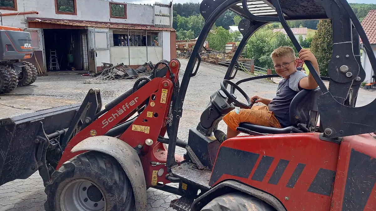 Ben (9) am Tag nach dem Brand auf dem elterlichen Hof: Auch beim Aufräumen nimmt er gerne alles selbst in die Hand - mit dem Radlader.