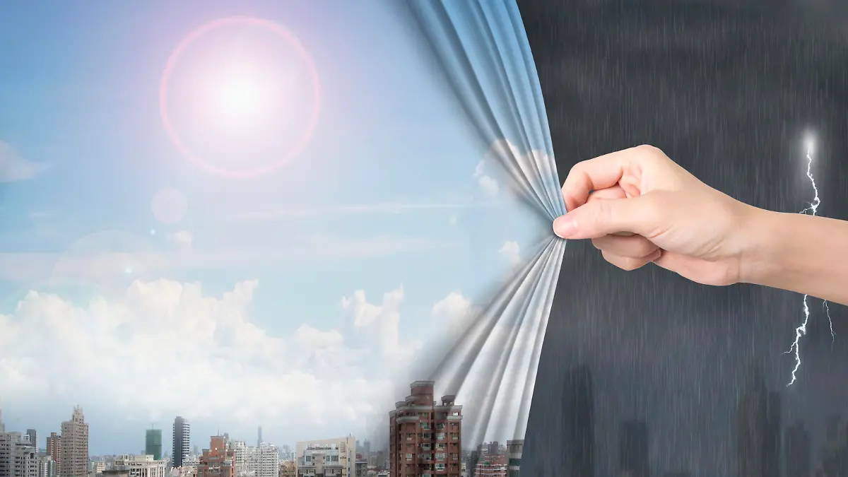 Woman hand pulling open sunny sky cityscape curtain covering stormy city.