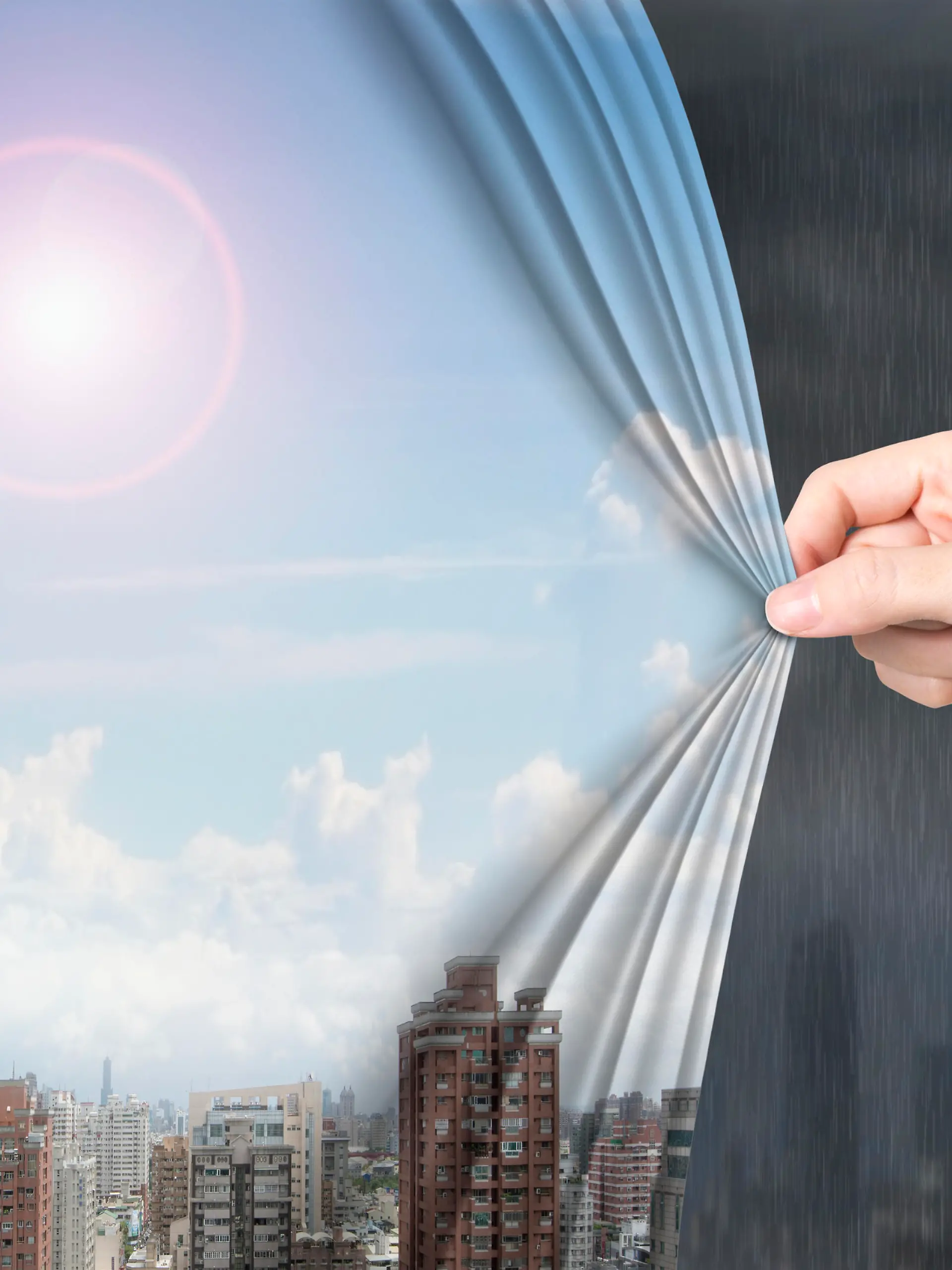 Woman hand pulling open sunny sky cityscape curtain covering stormy city.