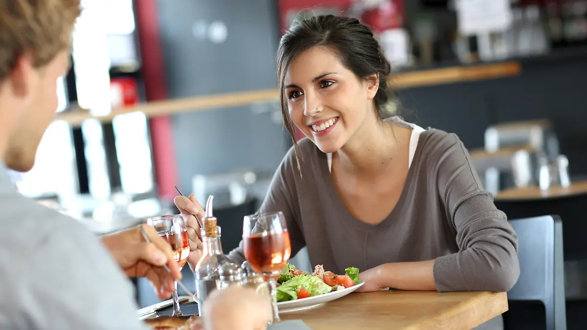 Young woman in restaurant eating lunch with boyfriend