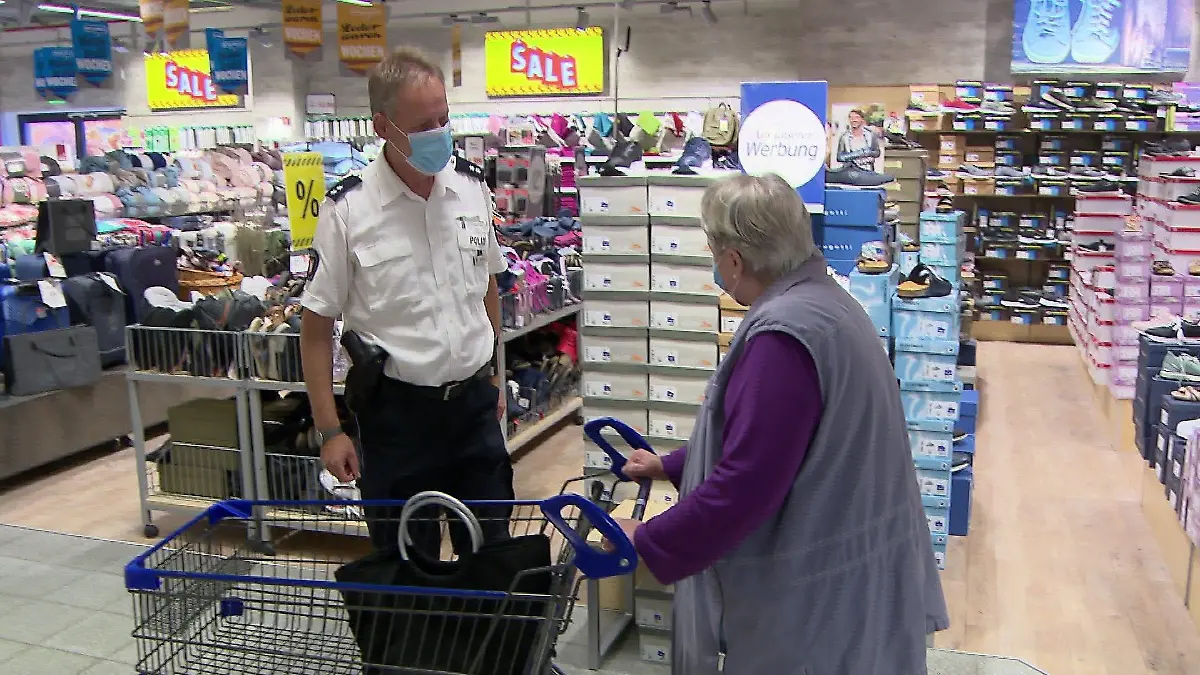 Polizeioberkommissar Christian Schmok klärt Supermarkt-Besuchende in Bad Bramstedt über Taschendiebe auf.
