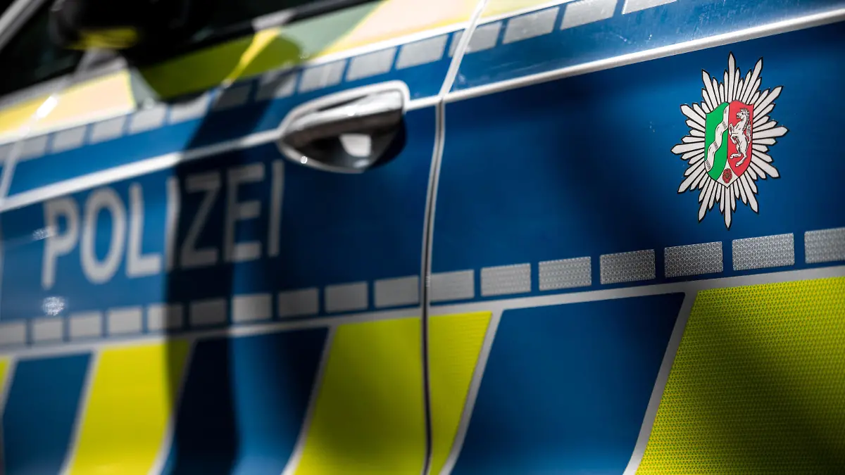 ILLUSTRATION - Das Wappen der Polizei Nordrhein-Westfalen und der Schriftzug «Polizei» sind auf einem Polizeiauto zu sehen. Bei der Polizei in Nordrhein-Westfalen werden 29 Beamte verdächtigt, an mindestens fünf rechtsextremen Chat-Gruppen beteiligt gewesen zu seinDer 69-jährige Tatverdächtige war am letzten Mittwoch festgenommen worden, danach aber mangels Haftgründen aus dem Polizeigewahrsam entlassen worden.